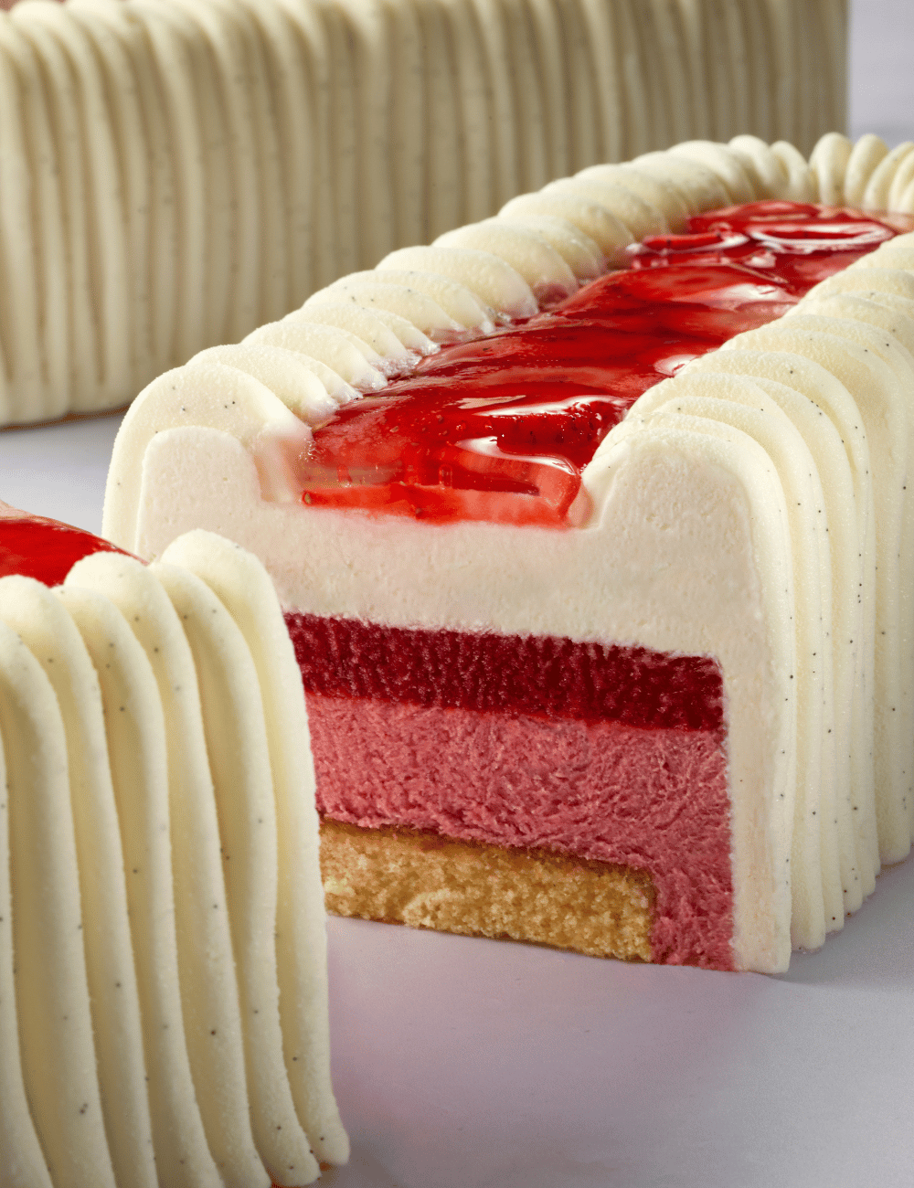 Silk Yule log cross-section: sliced strawberry in glacage, fruit paste layer, mousse and genoise base
